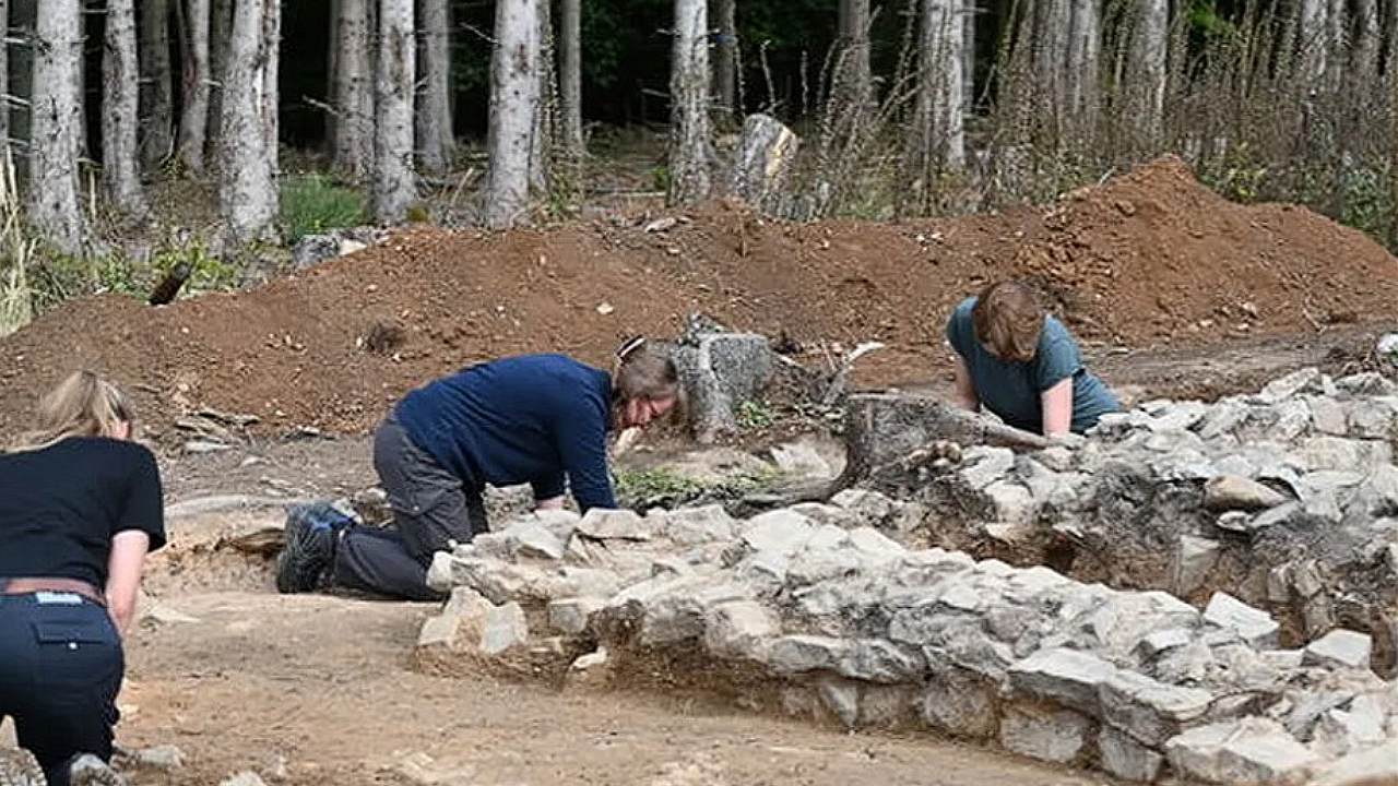 Archaeologists excavating stone ruins of an ancient Roman temple near Kapersburg fort in Germany
